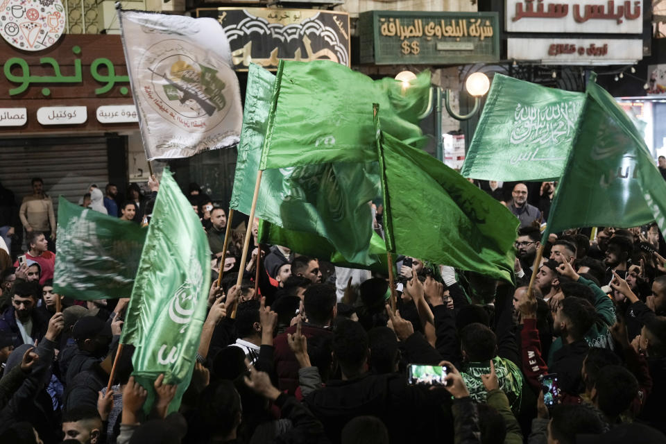 Palestinians wave Hamas flags as they celebrate the Israeli release of Palestinian prisoners in the West Bank city of Nablus, Friday, Nov. 24, 2023. The release came on the first day of a four-day cease-fire deal between Israel and Hamas during which the Gaza militants have pledged to release 50 hostages in exchange for 150 Palestinians imprisoned by Israel. (AP Photo/Majdi Mohammed)