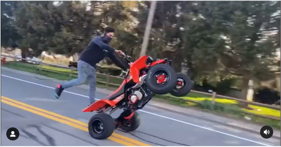 An ATV rider does stunts along a city street in Taunton, Massachusetts, in this still photo taken from an Instagram video.