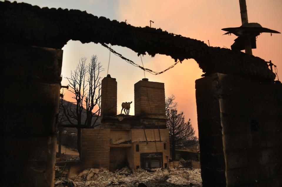 A statue sits on top of a house in Juniper Hills that was leveled by the Bobcat fire Saturday.