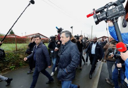 Francois Fillon, former French Prime Minister, member of the Republicans political party and 2017 presidential election candidate of the French centre-right walks in a street surrounded by journalists, as he visits a farm in Cambo les Bains, France March 25, 2017. REUTERS/Regis Duvignau