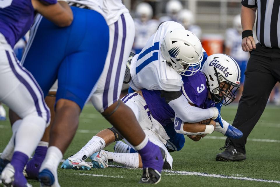 Ben Davis High School senior Thomas Gotkowski (3) is hit by IMG Academy High School junior Nathaniel Owusu-Boateng (11) as he runs the ball out of the backfield during the first half of an IHSAA varsity football game, Friday, Sept. 8, 2023, at Ben Davis High School.