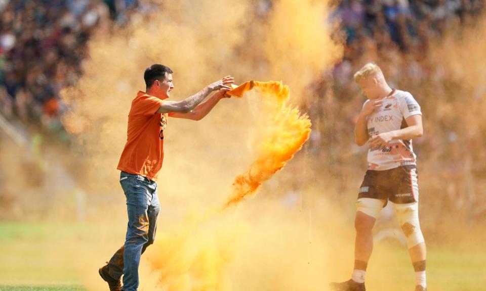 <span>A Just Stop Oil protester throws orange powder on the pitch during the Premiership final between Saracens and Sale at Twickenham in May 2023.</span><span>Photograph: Mike Egerton/PA</span>