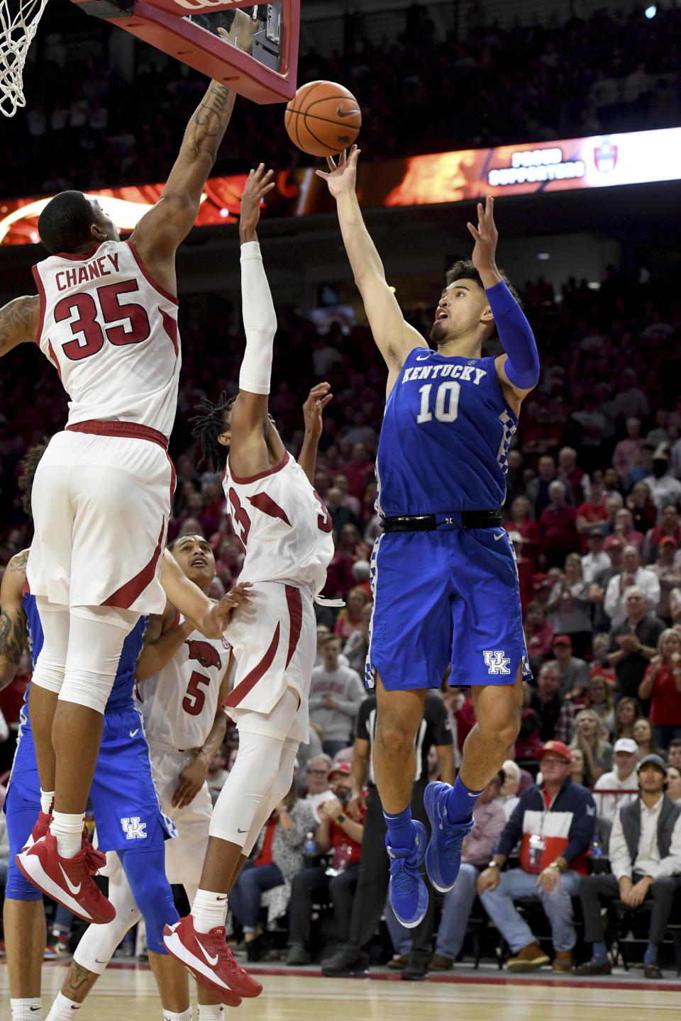 Kentucky guard Johnny Juzang (10) pulls up for a jump shot over Arkansas defenders Jimmy Whitt Jr. (33) and Reggie Chaney (35) during the second half of an NCAA college basketball game, Saturday, Jan. 18, 2020, in Fayetteville, Ark. (AP Photo/Michael Woods)