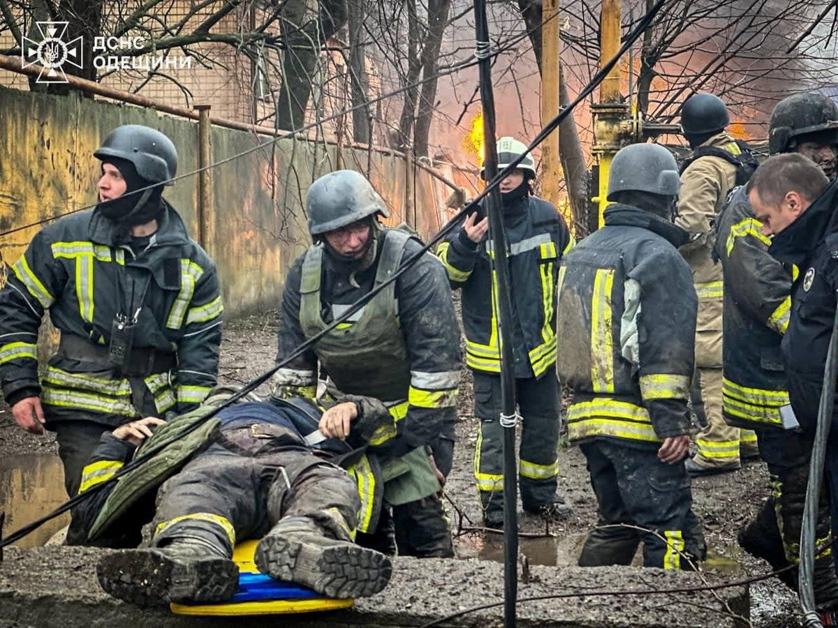 Rescuers carry an injured colleague at the site of a Russian missile strike in Odessa on Friday   (via REUTERS)