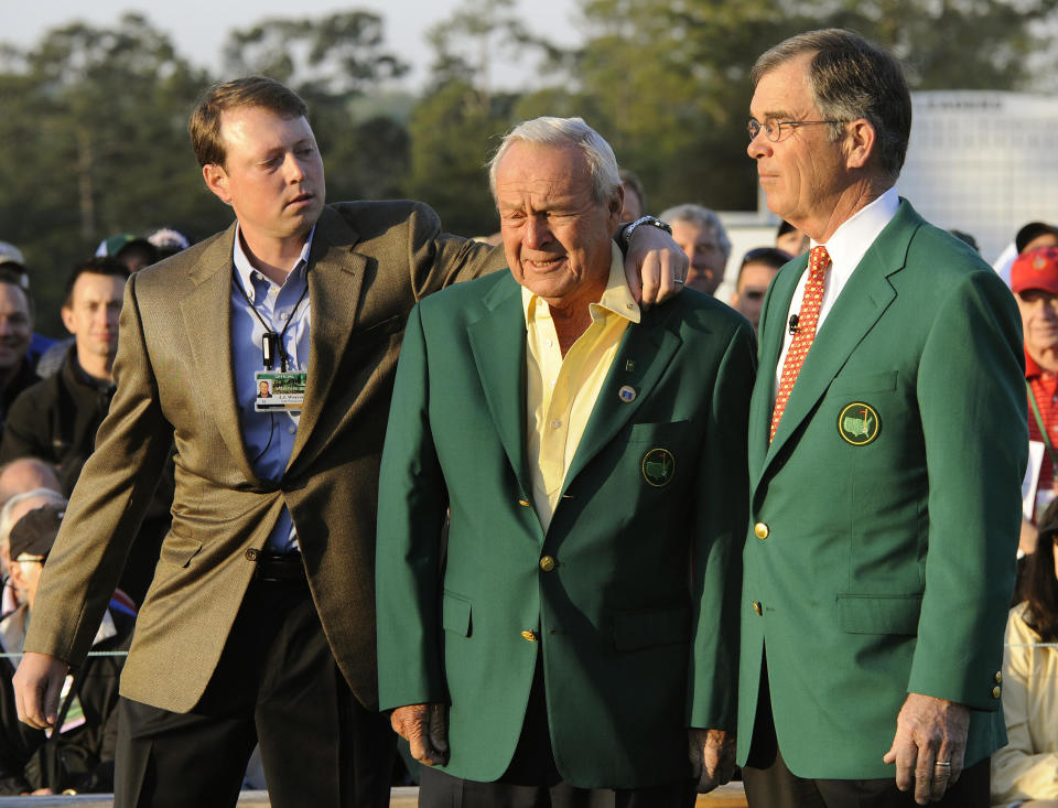 Honorary starter Arnold Palmer gets his jacket collar fixed as he poses with Augusta National Chairman Billy Payne after hitting his tee shot on the 1st hole to start the 1st round  at Augusta National Golf Club April 9, 2009 during  the 2009 Masters in Augusta, Georgia. AFP PHOTO/ TIMOTHY A. CLARY (Photo credit should read TIMOTHY A. CLARY/AFP via Getty Images)