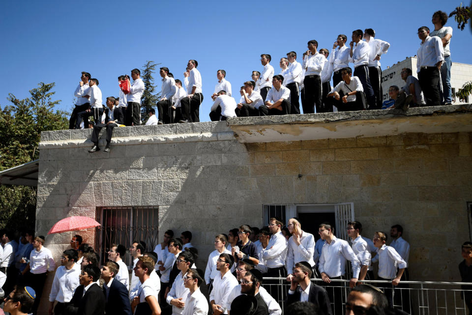 <p>Ultra-Orthodox Jewish youths watch the funeral ceremony for former Israeli president Shimon Peres taking place at Mount Herzl cemetery in Jerusalem on Sept. 30, 2016. (REUTERS/Dylan Martinez)</p>