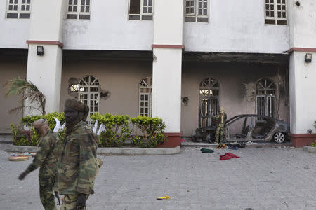 Chadian soldiers walk in front of a building that Boko Haram insurgents used as their base before being driven out by the Chadian military in Dikwa, Nigeria, March 2, 2015. REUTERS/Madjiasra Nako