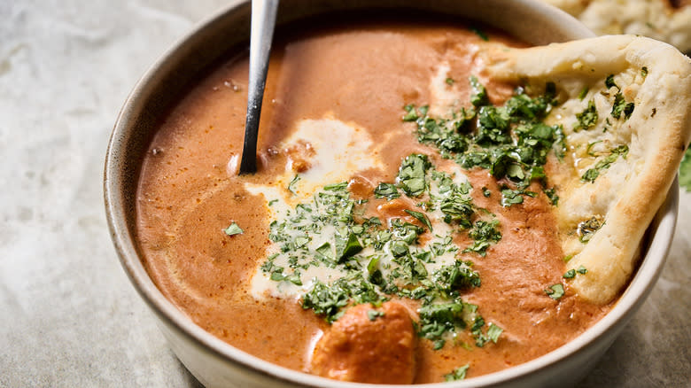 chicken tikka masala soup in bowl with naan