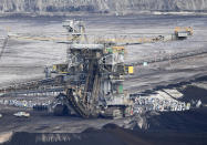 FILE-In this Nov. 24, 2019 file photo supporters of the climate movement Ende Gelaende protest at the coal-fired power station Lippendorf near Leipzig, Germany. The state governors Dietmar Woidke of Brandenburg, Michael Kretschmer of Saxony, Reiner Haseloff of Saxony-Anhalt and Armin Laschet of North Rhine-Westphalia meet in Berlin for the adoption by the Bundestag and Bundesrat of the laws on coal phase-out and structural strengthening in the affected federal states. (AP Photo/Jens Meyer)