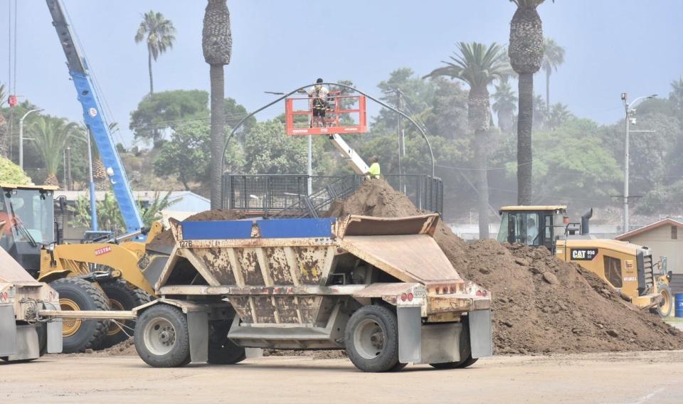 Workers dismantle the X Games at the Ventura County Fairgrounds Tuesday as part of a rushed transition to the Ventura County Fair, which begins Aug. 2.