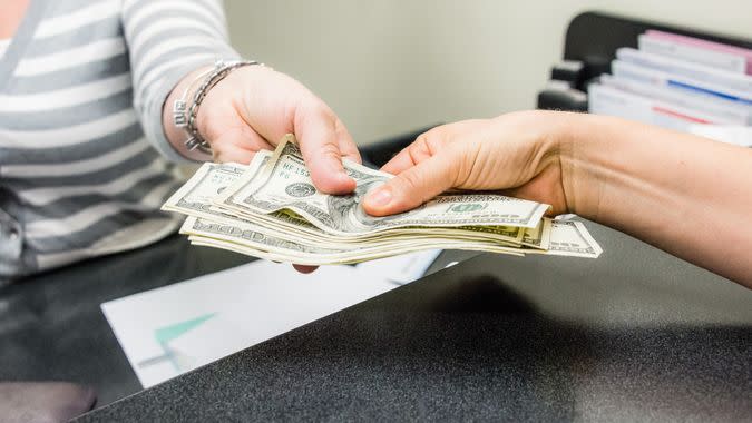 women hands getting cash in a bank teller.
