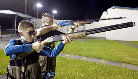 Damien Creller (L), 12, shoots during a clay target youth group shooting meeting in Sunrise, Florida, U.S. February 26, 2018. Picture taken February 26, 2018. REUTERS/Joe Skipper