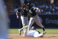 Chicago White Sox second baseman Josh Harrison, top right, prepares to throw to first to complete a double play after forcing out Juan Soto, bottom, at second on a ball hit by Manny Machado as White Sox's Elvis Andrus, top left, looks on during the sixth inning of a baseball game Sunday, Oct. 2, 2022, in San Diego. (AP Photo/Derrick Tuskan)