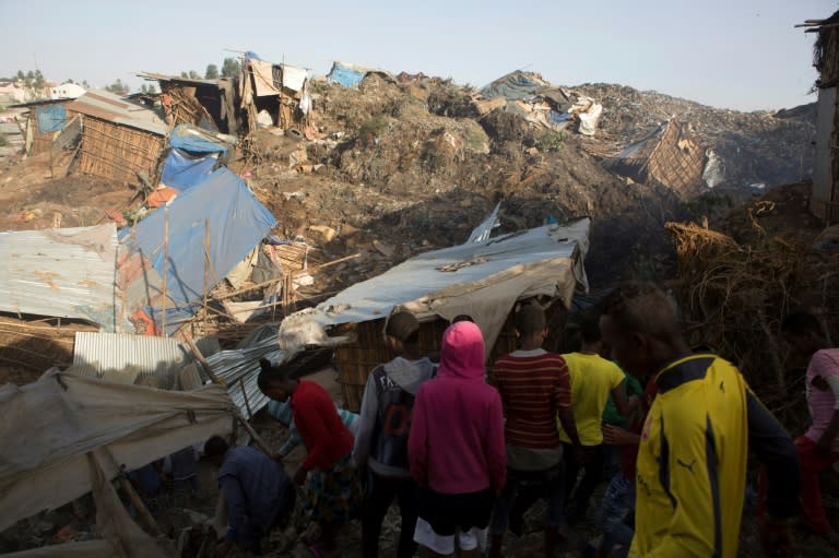 People survey the damage done to dwellings built near the main landfill of Addis Ababa on the outskirts of the city on March 12, 2017