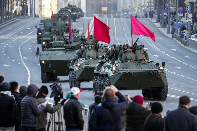 Los espectadores observan cómo los vehículos blindados rusos decorados con banderas rojas recorren la calle Tverskaya hacia la Plaza Roja para asistir a un ensayo del desfile militar del Día de la Victoria en Moscú, Rusia, el miércoles 4 de mayo de 2022. (AP Photo/Alexander Zemlianichenko) (Alexander Zemlianichenko/)