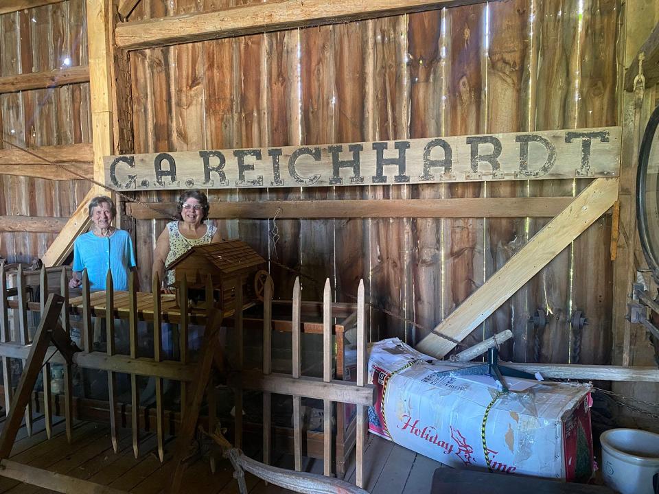 Reichhardt sisters Bonnie and Jo Ann by the newly-displayed sign at Will Carleton Poorhouse.