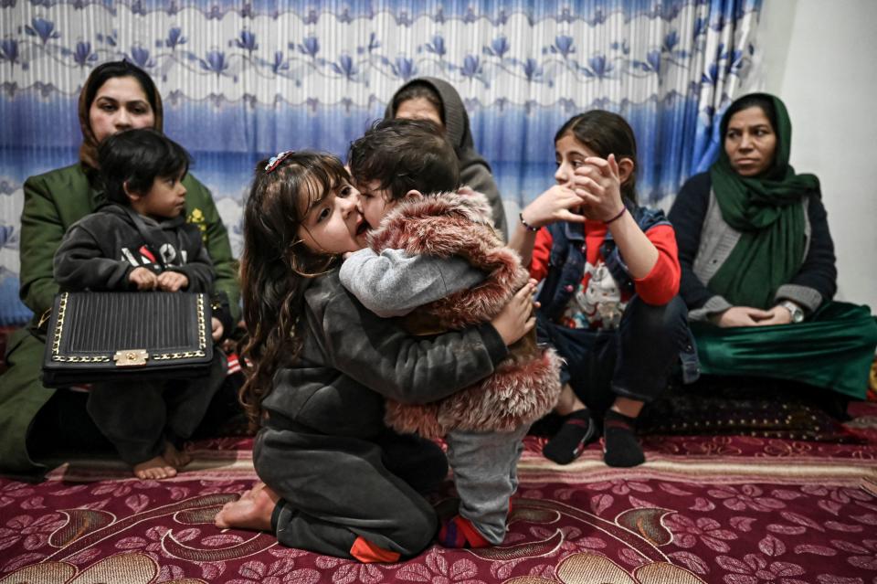 Sohail Ahmadi (R), who was separated from his parents at the airport in the chaos of the US evacuation of Afghanistan in August 2021, plays with the daughter of Hamid Safi, a taxi driver who found Sohail on the ground at Kabul airport and tracked down the family, at Sohail&#39;s grandfather&#39;s house in Kabul on January 9, 2022. (Photo by Mohd RASFAN / AFP) (Photo by MOHD RASFAN/AFP via Getty Images)