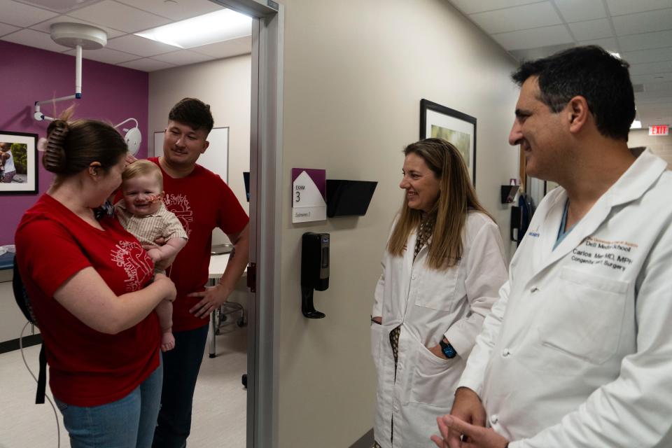 Abigail Robinson and Christian Rodriguez hold their son, Elias, while talking to Dr. Chesney Castleberry, left, and Dr. Carlos Mery on July 20 at Dell Children's Medical Center. Four weeks before, Castleberry helped procure a heart with a good heart valve for Mery to use to replace a bad valve in Elias.