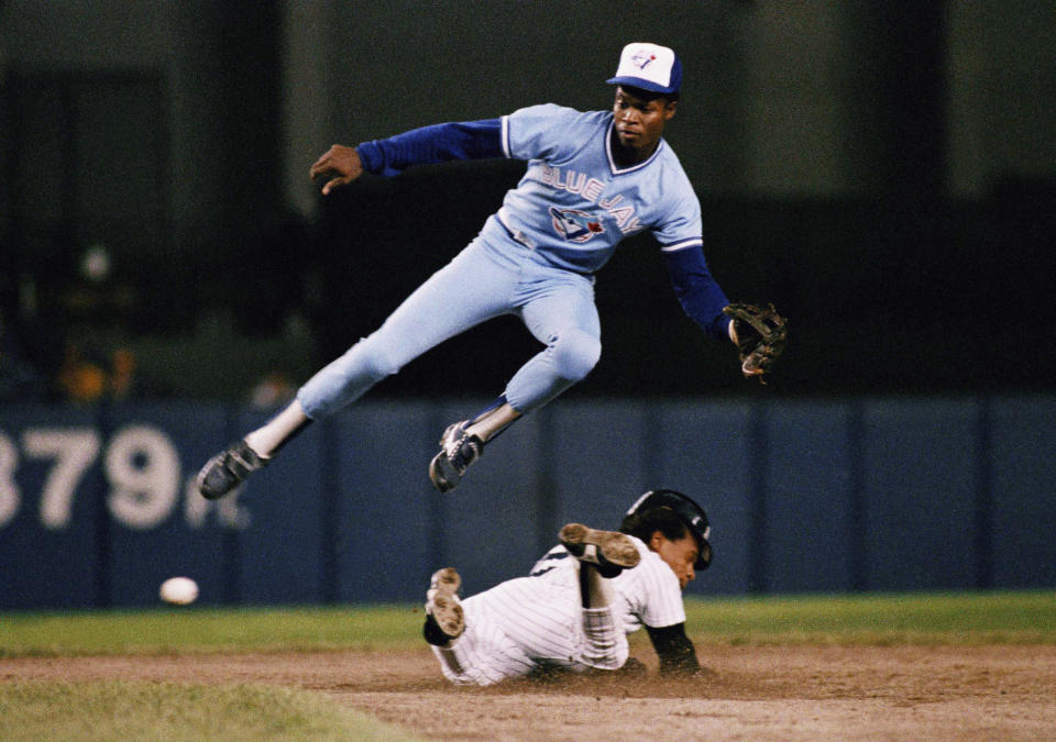 FILE - In this Sept. 18, 1987, file photo, New York Yankees' Rickey Henderson, bottom, steals second base below Toronto Blue Jays shortstop Tony Fernández during a baseball game in New York. Fernández, a stylish shortstop who made five All-Star teams during his 17 seasons in the major leagues and helped the Blue Jays win the 1993 World Series, died Sunday, Feb. 16, 2020, after complications from a kidney disease. He was 57. (AP Photo/G. Paul Burnett, File)