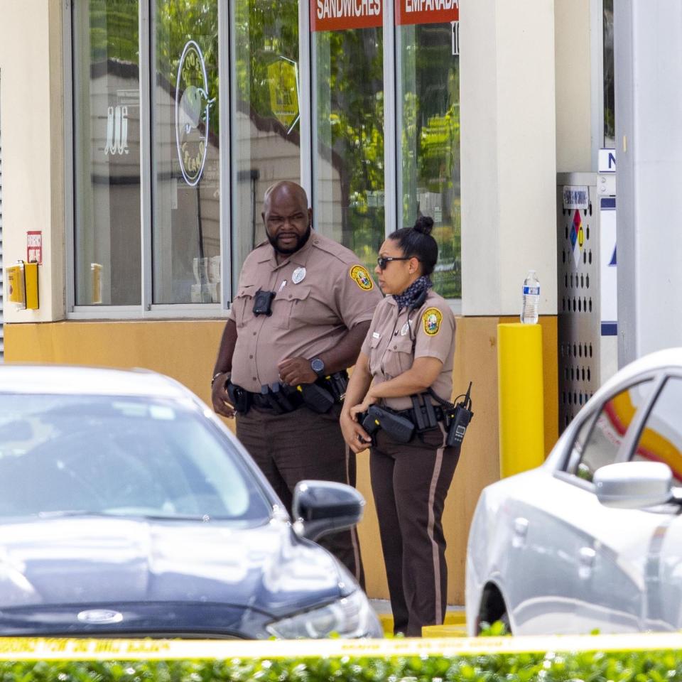 Miami-Dade Police officers are shown outside a Shell gas station near the scene of a shooting in Miami, Fla., on Sunday, June 6, 2021. Three people are dead and at least six others injured following a shooting at a Florida graduation party, the latest in a string of such violence in the Miami area, police said Sunday. One of those killed was a state corrections officer, Miami-Dade police Director Freddie Ramirez told news outlets. (Daniel A Varela/Miami Herald via AP)