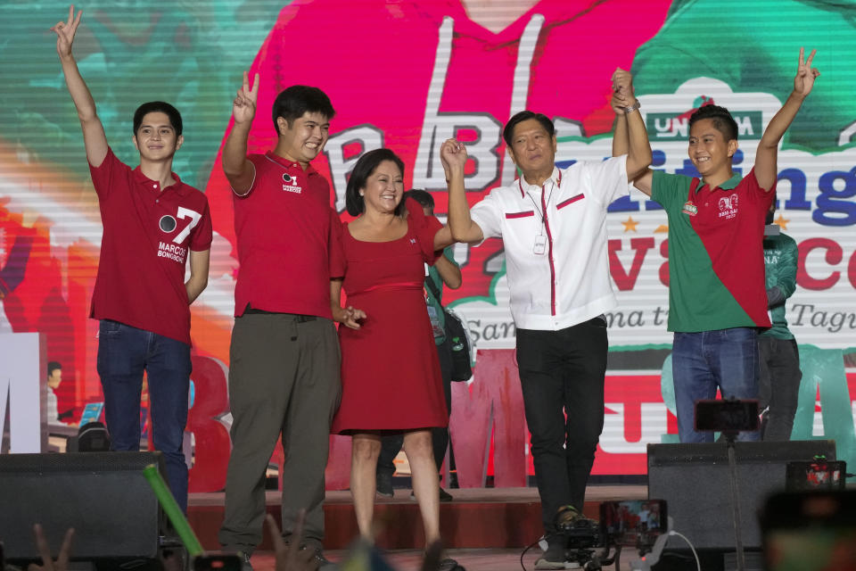 FILE - Presidential candidate, Ferdinand Marcos Jr., the son of the late dictator, poses with his family, from left, Simon, Vincent, wife Liza and Sandro during his last campaign rally known as "Miting De Avance" on May 7, 2022 in Paranaque city, Philippines. The winner of May 9, Monday's vote will inherit a sagging economy, poverty and deep divisions, as well as calls to prosecute outgoing leader Rodrigo Duterte for thousands of deaths as part of a crackdown on illegal drugs. (AP Photo/Aaron Favila, File)