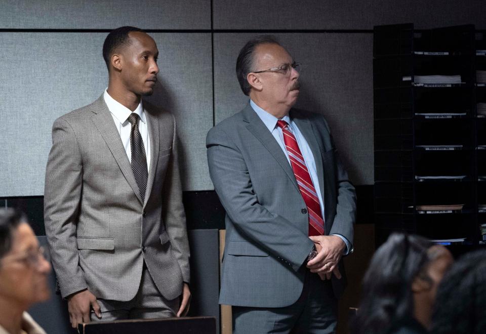  Travis Rudolph, left, watches a video with his defense attorneys Marc Shiner, right, the murder trial of former Florida State University football player Travis Rudolph in West Palm Beach, Florida on May 26, 2023.