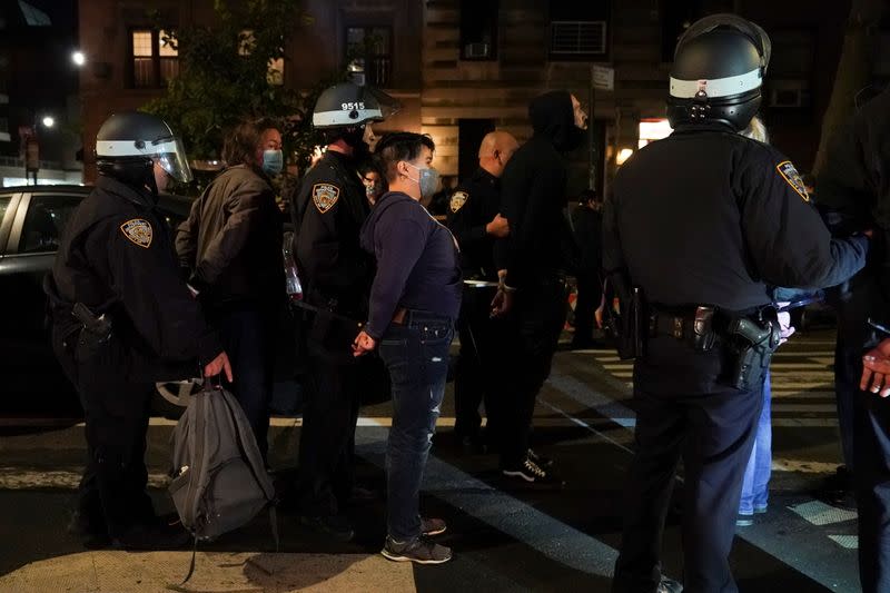 Police officers stand next to detained demonstrators near Washington Square park the day after Election Day in Manhattan, New York City