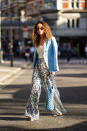 Yasmine Daas is seen wearing a pale blue blazer and shiny sequinned flared trousers. [Photo: Getty Images]