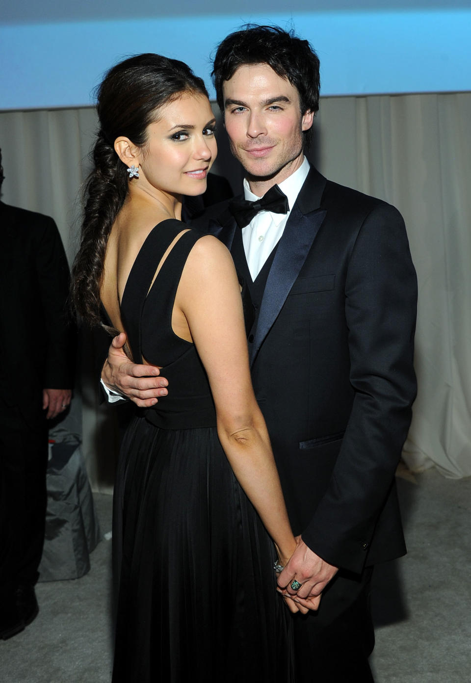 Nina Dobrev and Ian Somerhalder holding hands at a formal event