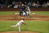 New York Yankees' Oswald Peraza, center right, hits into a double play on a pitch from Texas Rangers starting pitcher Martin Perez, front, as catcher Jonah Heim, center left, and umpire Andy Fletcher, rear, look on in the sixth inning of a baseball game in Arlington, Texas, Monday, Oct. 3, 2022. (AP Photo/Tony Gutierrez)