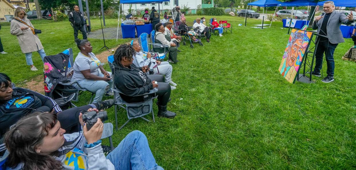 A large crowd listens as Nasser Metcalfe of New York speaks about his grandfather during the renaming of 34th Street in honor of Olympic athlete, U.S. representative and scholar Ralph Metcalfe on Saturday at 3401 W. Center St. in Milwaukee.