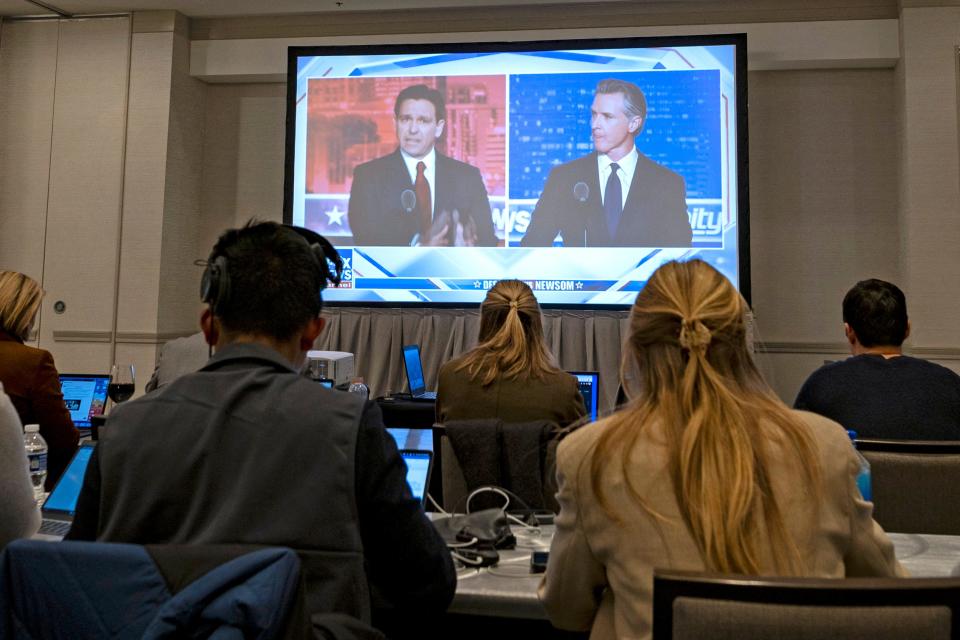 Florida Governor and Republican presidential hopeful Ron DeSantis (L) and California Governor Gavin Newsom (R) appear on screen from the press room during a debate held by Fox News, in Alpharetta, Georgia, on November 30, 2023. (Photo by CHRISTIAN MONTERROSA/AFP via Getty Images)