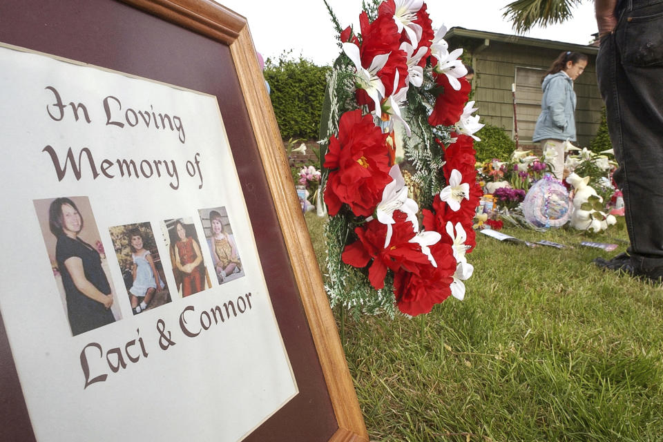 FILE - Photographs of Laci Peterson are placed at a memorial outside the home of Scott and Laci Peterson, Sunday, April 20, 2003 in Modesto, Calif. A California judge has rejected a new murder trial for Scott Peterson. The decision Tuesday, Dec. 20, 2022, comes nearly 20 years after Peterson was charged with dumping the bodies of his pregnant wife, Laci, and the unborn child they planned to name Conner into San Francisco Bay on Christmas Eve 2002. (AP Photo/Paul Sakuma, File)