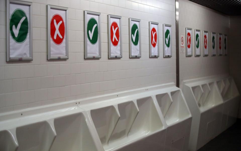Covid-19 signage is seen in the toilets at a football ground - Football fans warned they may not be able to use the toilet when crowds return to stadiums - GETTY IMAGES