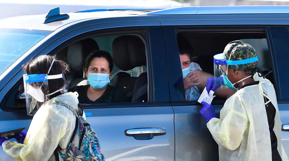 <p>People pull up in their vehicles for Covid-19 vaccines in the parking lot of The Forum in Inglewood, California</p> (AFP via Getty Images)