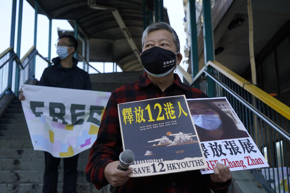 Pro-democracy activists, including Lee Cheuk-Yan, right, hold placards with the picture of the Chinese citizen journalist Zhang Zhan as they march to the Chinese central government's liaison office, in Hong Kong, Monday, Dec. 28, 2020. They demanded the release of the 12 Hong Kong activists detained at sea by Chinese authorities. (AP Photo/Kin Cheung)