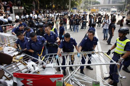 Police remove a barricade at a protest site in Admiralty near the government headquarters in Hong Kong October 14, 2014. REUTERS/Carlos Barria