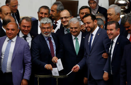Binali Yildirim (3rd R), the likely new leader of Turkey's ruling AK Party, poses with MPs as he votes during a debate at the Turkish parliament in Ankara, Turkey, May 20, 2016. REUTERS/Umit Bektas