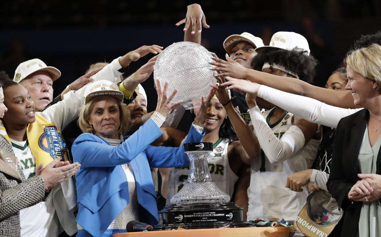 Baylor coach Kim Mulkey, in blue, and players raise part of the NCAA/WBCA coaches' trophy after Baylor defeated Notre Dame 82-81 in the Final Four championship game of the NCAA women's college basketball tournament, Sunday, April 7, 2019, in Tampa, Fla. (AP Photo/John Raoux)