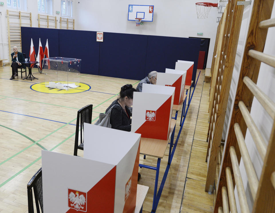 People vote by ballot in an election to the Polish parliament in Warsaw, Poland, on Oct. 13, 2019. Poles are voting Sunday in a parliamentary election, that the ruling party of Jaroslaw Kaczynski is favored to win easily, buoyed by the popularity of its social conservatism and generous social spending policies that have reduced poverty. (AP Photo/Czarek Sokolowski)