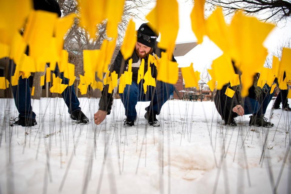 In this file photo, Allen Atkinson plants yellow flags, representing members of the Jewish community killed during the Holocaust, during the Field of Flags set up Feb. 25, 2022, at Colorado State University's Lory Student Center Plaza. Each flag planted represents 5,000 killed during the Holocaust. This year's Field of Flags will be set up Friday, Feb. 16.