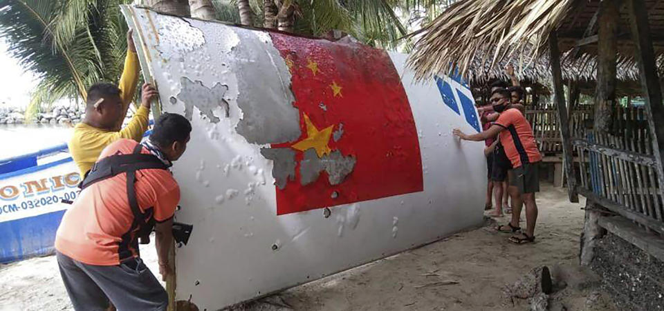 FILE - In this photo provided by the Philippine Coast Guard, Coast Guard personnel carry debris, which the Philippine Space Agency said has markings of the Long March 5B (CZ-5B) Chinese rocket that was launched on July 24, after it was found in waters off Mamburao, Occidental Mindoro province, Philippines on Aug. 2022. Metal debris from Chinese rocket launches, some showing a part of what appears to be Chinese flag, have been found in Philippine waters in at least three other instances. (Philippine Coast Guard via AP, File)