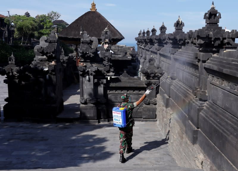 An Indonesian soldier sprays disinfectant to prevent the spread of coronavirus disease (COVID-19) at Tanah Lot temple in Tabanan, Bali