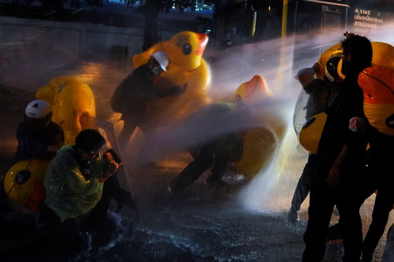 Demonstrators use inflatable rubber ducks as shields to protect themselves from water cannons during an anti-government protest, outside the parliament in Bangkok