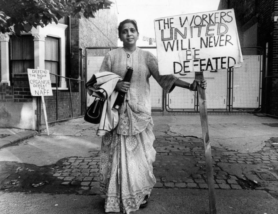 Picket23rd August 1977: Treasurer of the Grunwick strike committee Mrs Jayaben Desai, she has been picketing for a year. A sign says, ‘Defend the Right to Organise Defeat the NAFF’. (Photo by Graham Wood/Evening Standard/Getty Images) England;black white;format landscape;female;house;barricade;sign;Europe;ES 12;ES
