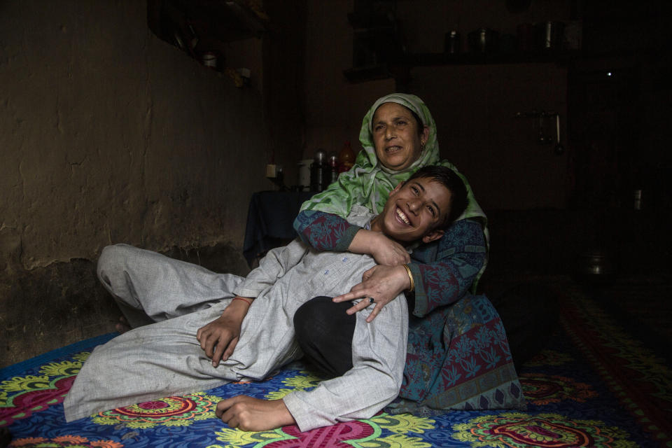 Kashmiri woman Zamrooda with her son Sahil Majeed whom she saved from a leopard attack in 2009 in Srinagar, Indian controlled Kashmir, Thursday, Sept. 10, 2020. Zamrooda said despite her wounds and continuous bleeding she fought with leopard and dragged her son Sahil majeed from the mouth of a leopard as he attacked them in their village in 2009. " I had finished almost all work at my home. I supposed to go in fields for work. I saw something strange animal he jumped on me I was not able to move I was bleeding he tore my clothes suddenly it comes to my mind that my son was outside I ran away towards my son I hit leopard's mouth with stick and pull my son out from his mouth. He escaped and entered others cow shed where he killed a cow. Then I was shifted to hospital by locals for treatment. my son was 4 years old that time." (AP Photo/Mukhtar Khan)