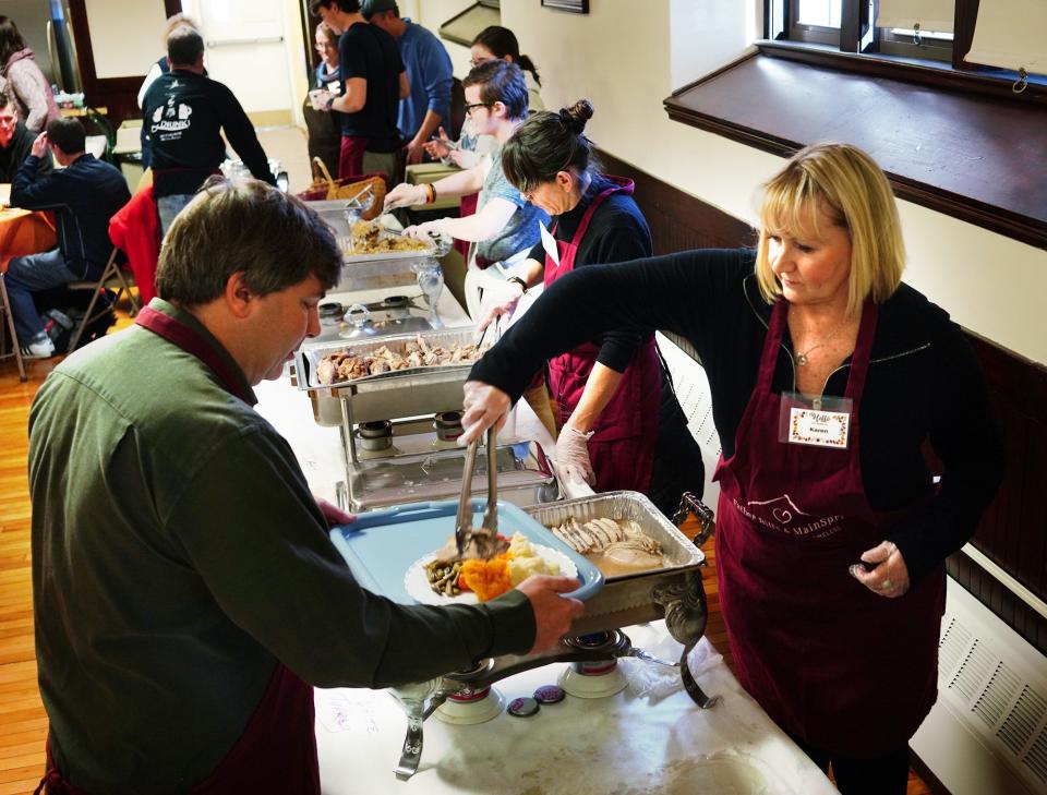 Karen Scheele, of Rockland, volunteers serving turkey at the annual Father Bills Thanksgiving Dinner held at Christ Church, in Quincy in 2018.