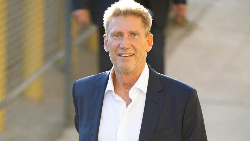 Gerry Turner in a dark suit smiles as he arrives arrives at TV studio