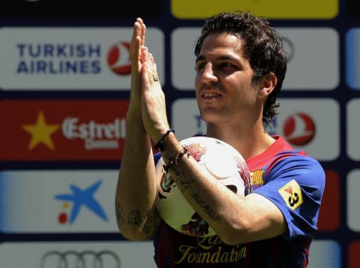 Barcelona's new player Cesc Fabregas applauds during his official presentation at the Camp Nou's stadium in Barcelona, after signing a new contract with the Catalan club. Fabregas completed his marathon move from Arsenal to Barcelona by signing a five-year contract that brought him "back home" to his boyhood club after eight years