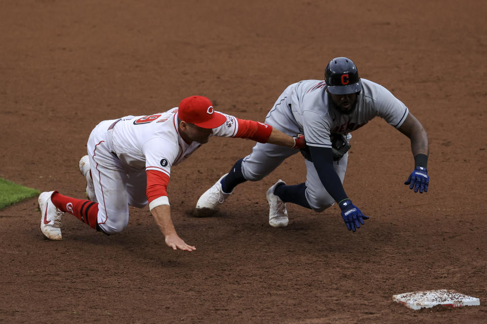 Cincinnati Reds' Joey Votto, left, dives and tags out Cleveland Indians' Franmil Reyes, right, for a triple play during the seventh inning of a baseball game in Cincinnati, Saturday, April 17, 2021. Indians' Josh Naylor lined out to Reds' Joey Votto to start the triple play. (AP Photo/Aaron Doster)